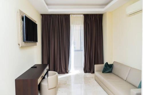 a living room with a couch and a television at Hôtel Bachou in Dakar