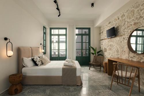 a bedroom with a bed and a desk in it at Soleil boutique house with terrace in Rethymno Town