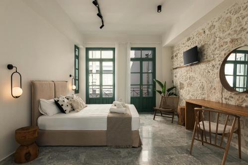 ein Schlafzimmer mit einem Bett und einem Schreibtisch. in der Unterkunft Soleil boutique house with terrace in Rethymno