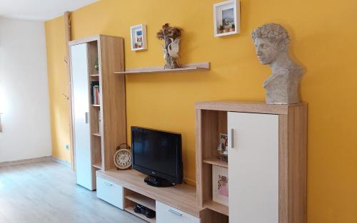 a room with a tv and a statue on a shelf at Apartamento turístico en el centro de Benavente in Benavente