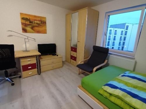 Schlafzimmer mit einem Bett und einem Schreibtisch mit einem Computer in der Unterkunft Voll ausgestattetes Apartment in Kassel