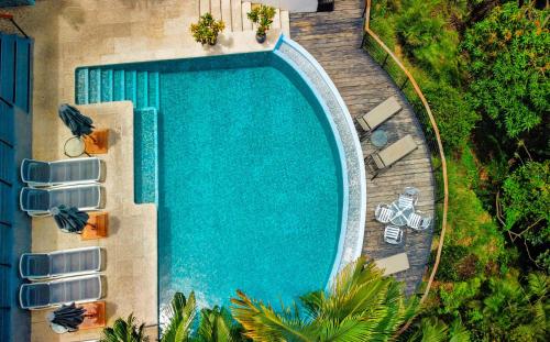 an overhead view of a swimming pool with lounge chairs at Villa Roca Boutique Resort & Suites - ADULT ONLY in Manuel Antonio