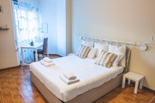 una camera da letto con un grande letto bianco con asciugamani di Cozy flat with terrace at Trastevere train station a Roma