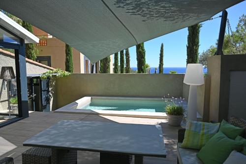a swimming pool with a table and an umbrella at Villa ALFONSA in Saint-Raphaël