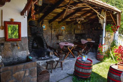 an outdoor patio with a stone fireplace and a table and chairs at Apartman Denčić Zavojsko jezero in Pirot