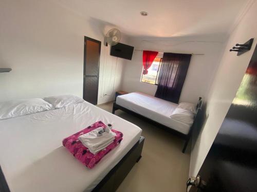- une chambre avec 2 lits et une valise rose dans l'établissement Hotel La Estrella, à San Luis