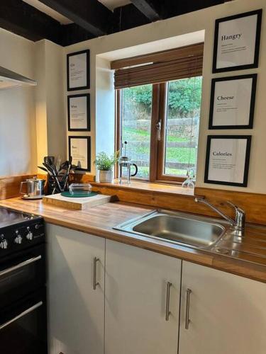 a kitchen with a sink and a window at Stable Cottage in Germansweek