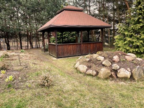 a gazebo in a field with a pile of rocks at Agroturystyka Włochate Ranczo in Mochowo