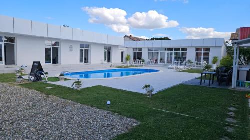 une maison avec une piscine dans la cour dans l'établissement Fantastic camp, à Piteşti