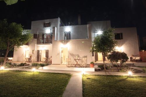 a large white house at night with lights at Asterias in Skiros