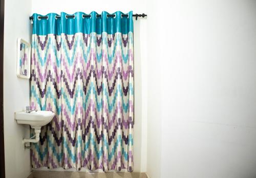 y baño con cortina de ducha y lavamanos. en Green Apartments - AC 1 BHK Apartments in Cheruthuruthi, Thrissur, en Cheruthuruthi