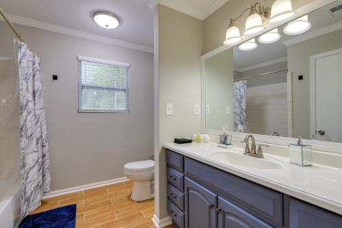a bathroom with a sink and a toilet and a mirror at Lovely Riverdale Retreat with Private Pool and Yard! in Riverdale