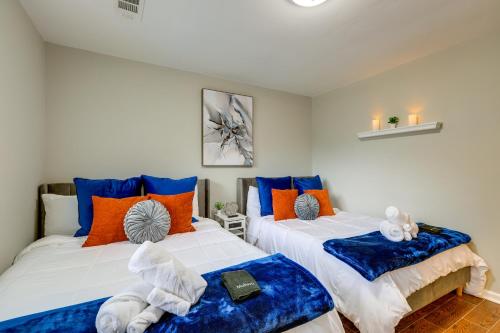 two beds in a room with blue and orange pillows at Lovely Riverdale Retreat with Private Pool and Yard! in Riverdale