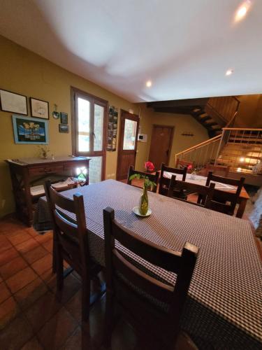 ein Esszimmer mit einem Tisch, Stühlen und einer Treppe in der Unterkunft Casa Macianet in Beranui