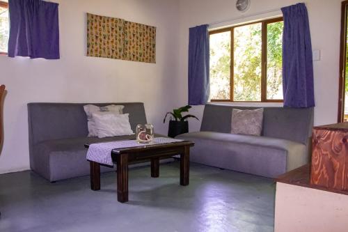 uma sala de estar com dois sofás e uma mesa de centro em Whistling Woods em Empangeni