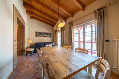 una sala da pranzo con un grande tavolo e sedie in legno di Ciasa Buro - Gimel a Moena