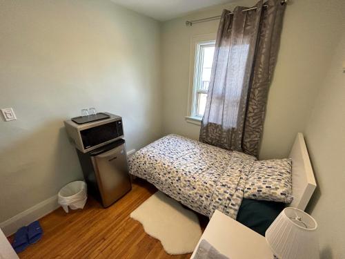 Cette petite chambre comprend un lit et une fenêtre. dans l'établissement TORONTO Midtown Spot 1, à Toronto