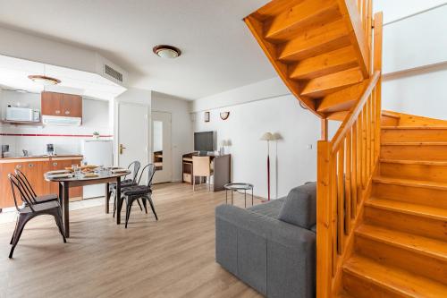 a living room with a couch and a table at Appart'City Confort Pau Centre in Pau