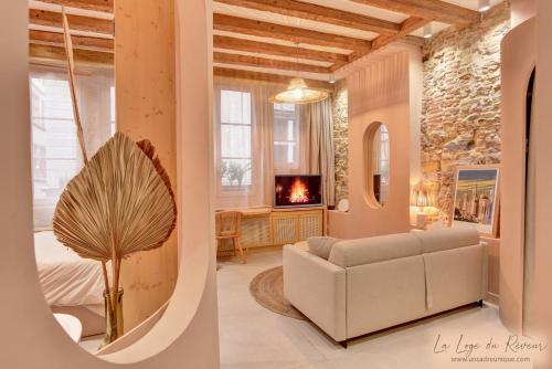 a living room with a white couch and a fireplace at La Loge du Rêveur - Spa - Vieux-Lyon in Lyon