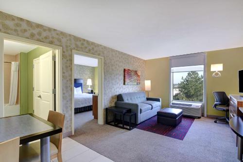a hotel room with a bed and a living room at Home2Suites by Hilton Augusta in Augusta