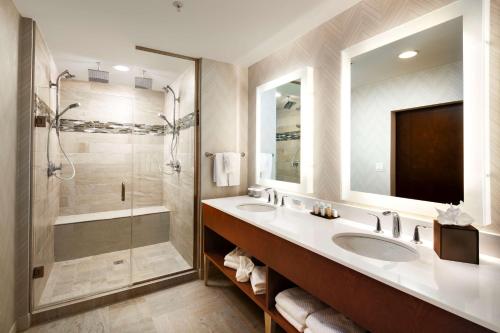 a bathroom with two sinks and a shower at Embassy Suites Amarillo Downtown in Amarillo