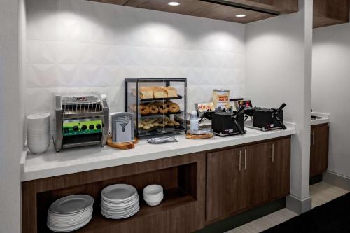 una cocina con encimera con platos y comida en Hilton Garden Inn Atlanta Perimeter Center, en Atlanta