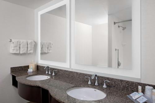 a bathroom with two sinks and a large mirror at Hilton Garden Inn Atlanta Perimeter Center in Atlanta