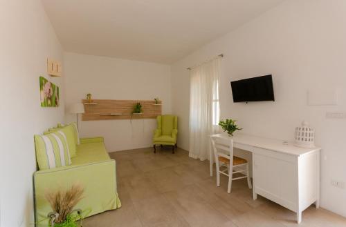 a living room with a desk and a green chair at Agriturismo Giorgio in Mattinata