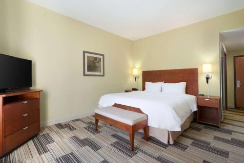 a hotel room with a bed and a flat screen tv at Hampton Inn & Suites Birmingham Airport Area in Birmingham