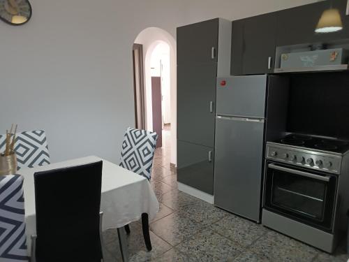 a kitchen with stainless steel appliances and a table with a chair at Renas home in Anavyssos