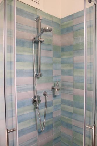 La salle de bains est pourvue d'une douche à rayures colorées. dans l'établissement Giobo Rooms, à Siniscola