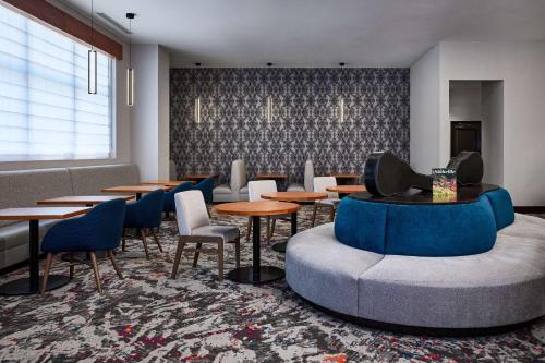 a dining room with tables and chairs and a couch at Hilton Garden Inn Nashville Downtown Convention Center in Nashville