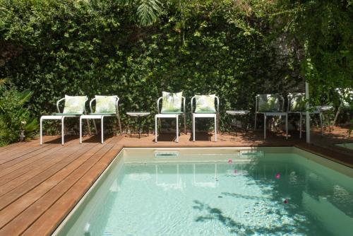 - un groupe de chaises et une piscine avec une terrasse dans l'établissement Casa do Barao, à Lisbonne