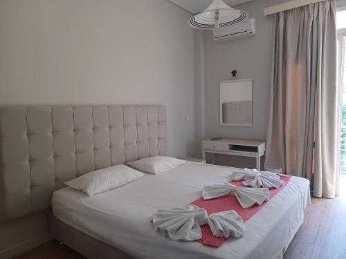 a bedroom with a white bed with two towels on it at City Center Hotel in Kalamata