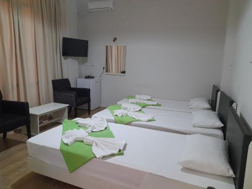 a group of four beds in a room at City Center Hotel in Kalamata