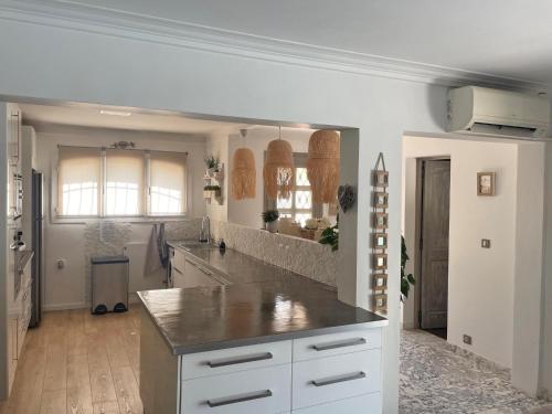 une cuisine avec des armoires blanches et un comptoir dans l'établissement le Gabron, à Puget-sur Argens