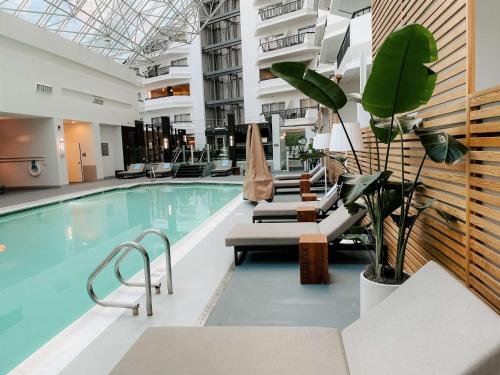 a swimming pool with lounge chairs in a building at Hilton Boston-Woburn in Woburn