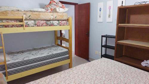 a room with two bunk beds and a bed at Praia Grande, Canto do Forte, Apto ,2 noites seguidas , apenas 2 diárias com Wi-Fi in Praia Grande