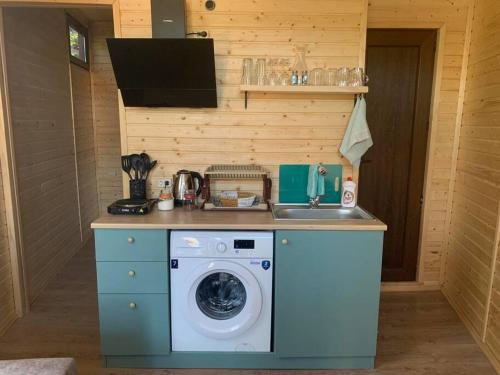 a kitchen with a washing machine and a sink at C`est la vie in Mtskheta