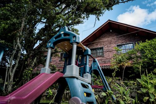 a playground with a slide in front of a house at Stone Cabins Boquete in Boquete