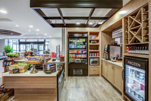 a coffee shop with a counter and a refrigerator at Hilton Garden Inn Boston Waltham in Waltham