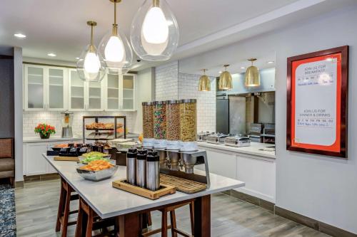 a kitchen with a table with food on it at Hilton Garden Inn Boston Waltham in Waltham