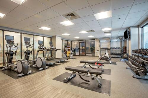 a gym with treadmills and ellipticals in a room at Hilton Garden Inn Boston Waltham in Waltham