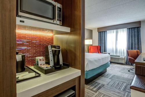 a hotel room with a bed and a television at Hilton Garden Inn Boston Waltham in Waltham