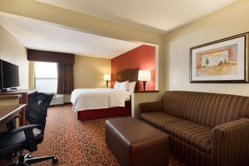 a hotel room with a bed and a couch at Hampton Inn Battle Creek in Battle Creek