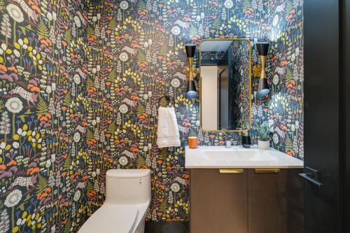 a bathroom with a toilet and a colorful wallpaper at Spacious Michigan Home about 6 Mi to Boyne Mountain! in Boyne City