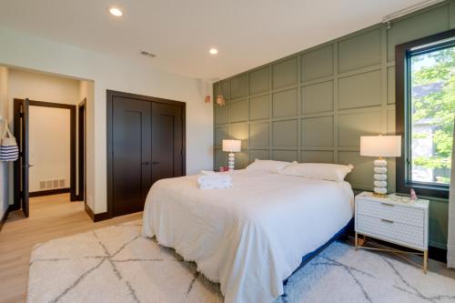 a bedroom with a large white bed and a window at Spacious Michigan Home about 6 Mi to Boyne Mountain! in Boyne City
