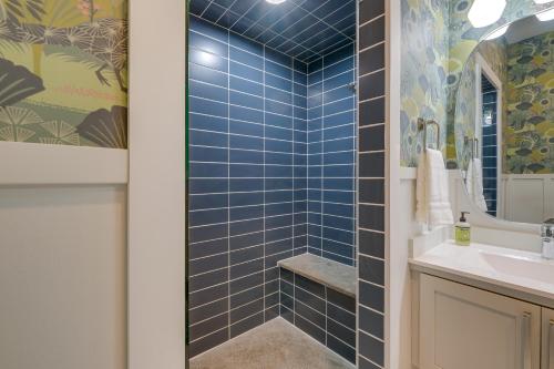 a blue tiled bathroom with a sink and a shower at Spacious Michigan Home about 6 Mi to Boyne Mountain! in Boyne City