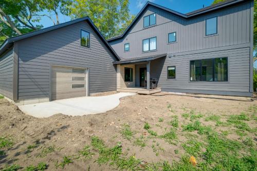 a house with a garage and a driveway at Spacious Michigan Home about 6 Mi to Boyne Mountain! in Boyne City