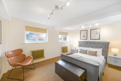 - une chambre avec un lit et une chaise dans l'établissement Central 2Bed Apartment near Barbican & Farringdon FREE WIFI by City Stay Aparts London, à Londres